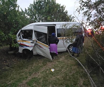 Crashed white minibus taxi with visible damage to the passenger side door after accident on R34 near Empangeni.