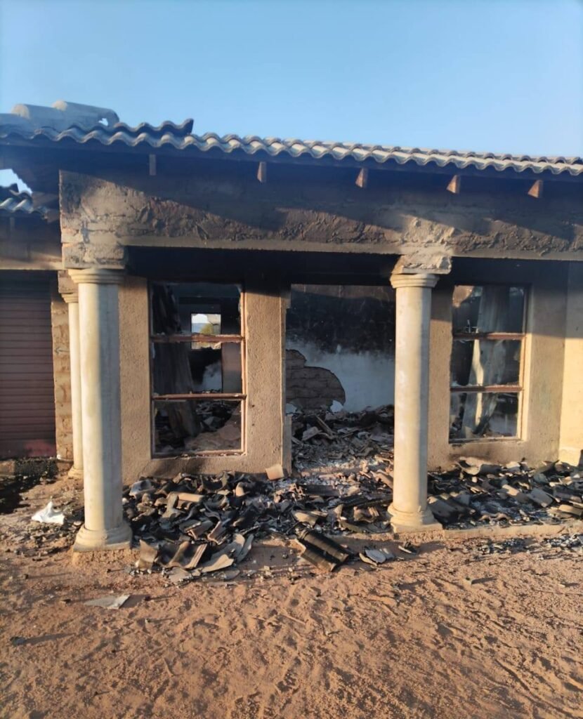 Close-up of the fire damage at Steve Biko Phase 4 house showing soot, collapsed ceiling, and burnt debris