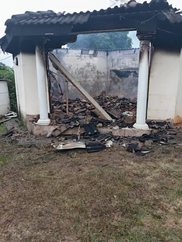 Exterior view of a burnt house in Ndwedwe showing extensive fire damage after a domestic incident.