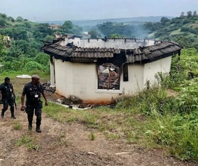 Security officers from Reaction Unit South Africa leaving a house in Ndwedwe after responding to a fire.